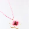 Helmillä koristeltu kaulakoru, jossa hibiskus-riipus